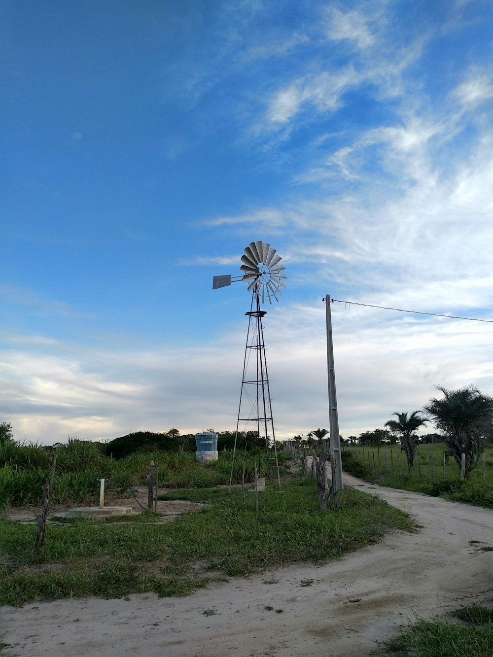 a windmill sitting on top of a lush green field