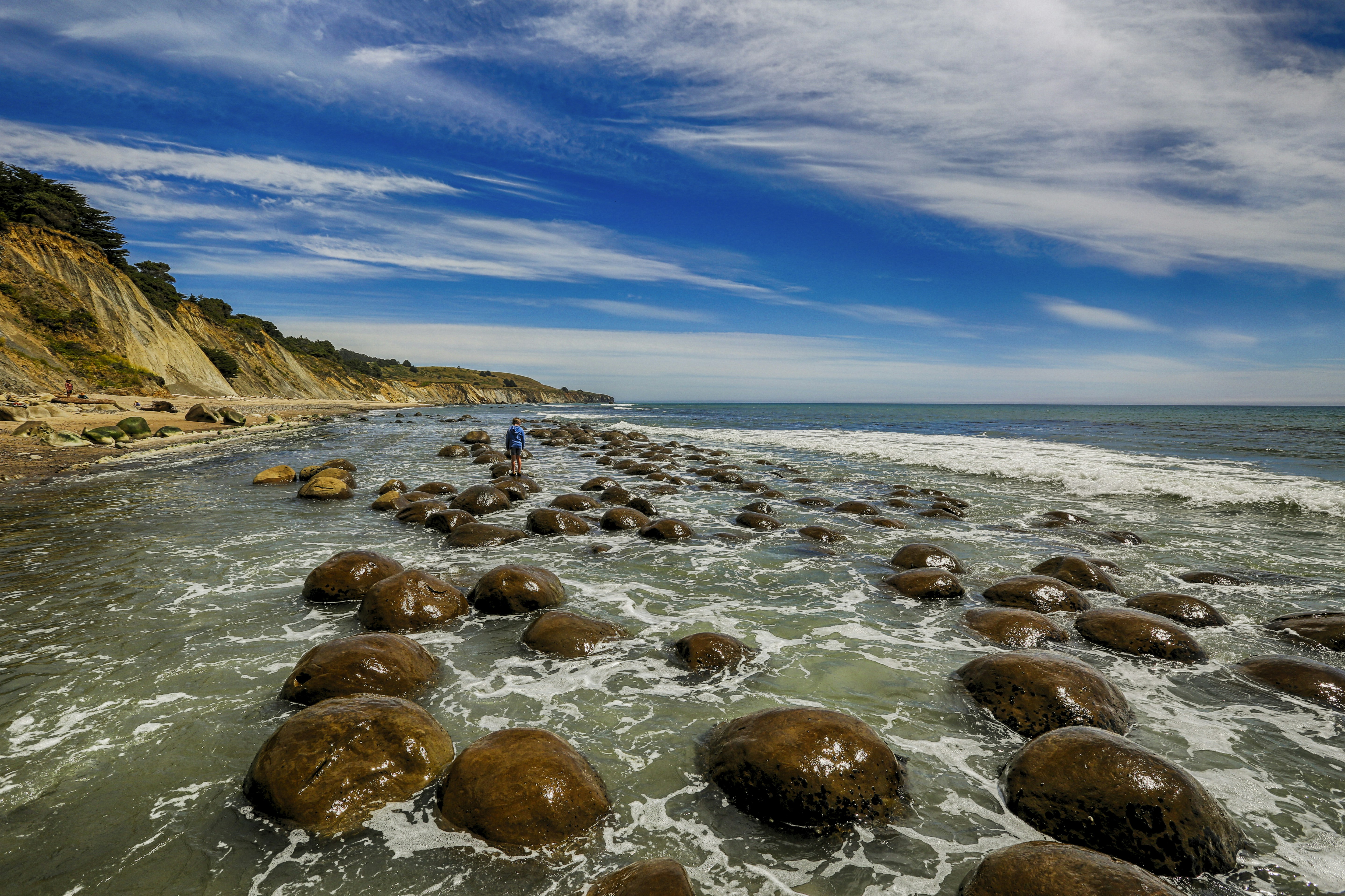 a man standing on top of a rocky beach next to the ocean, Most unique beach in all of California.