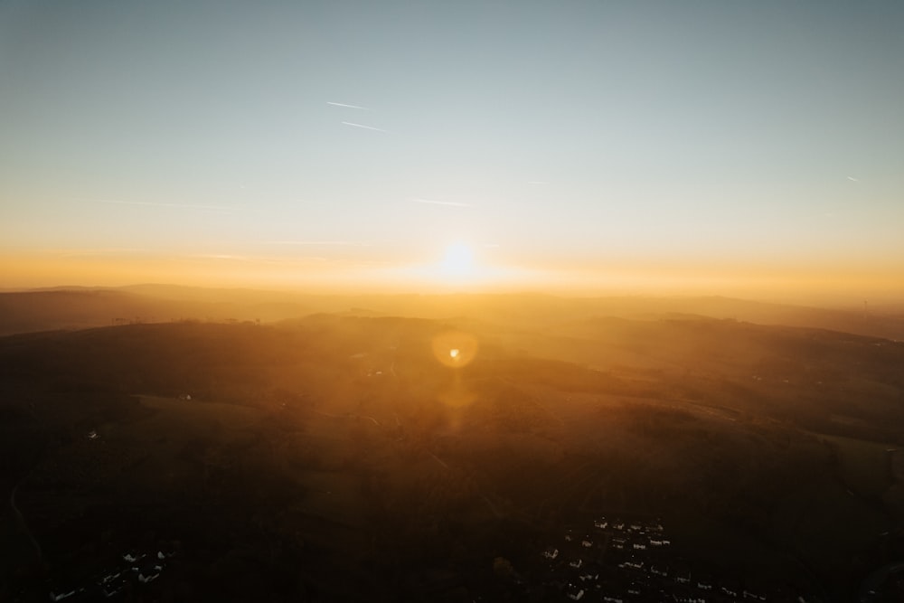 the sun is setting over a mountain range