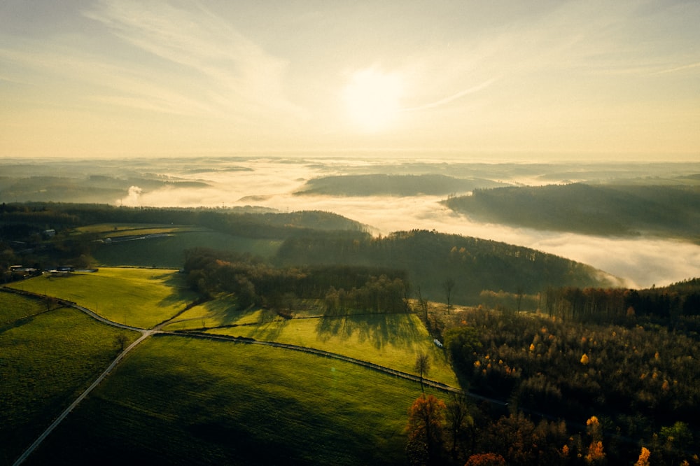 the sun is shining over a green valley