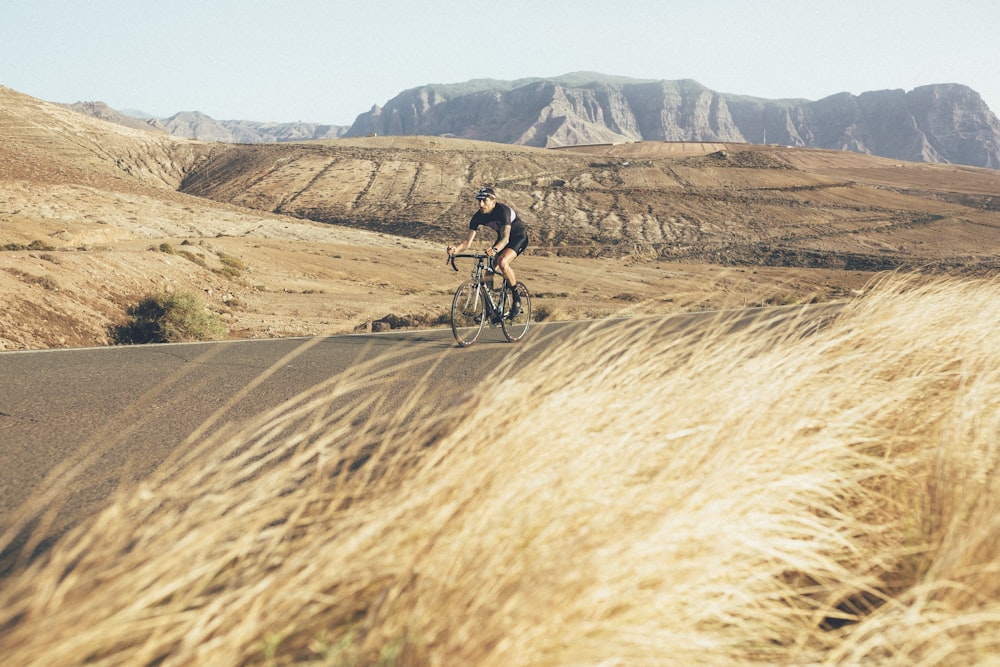 a man riding a bike down a dirt road