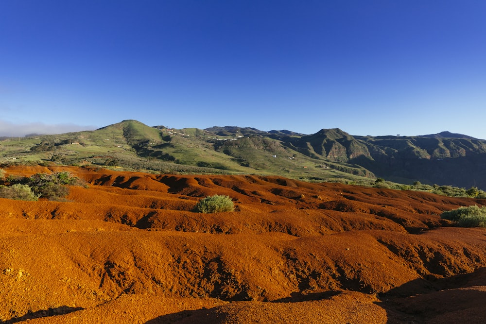 a view of a mountain range covered in red dirt