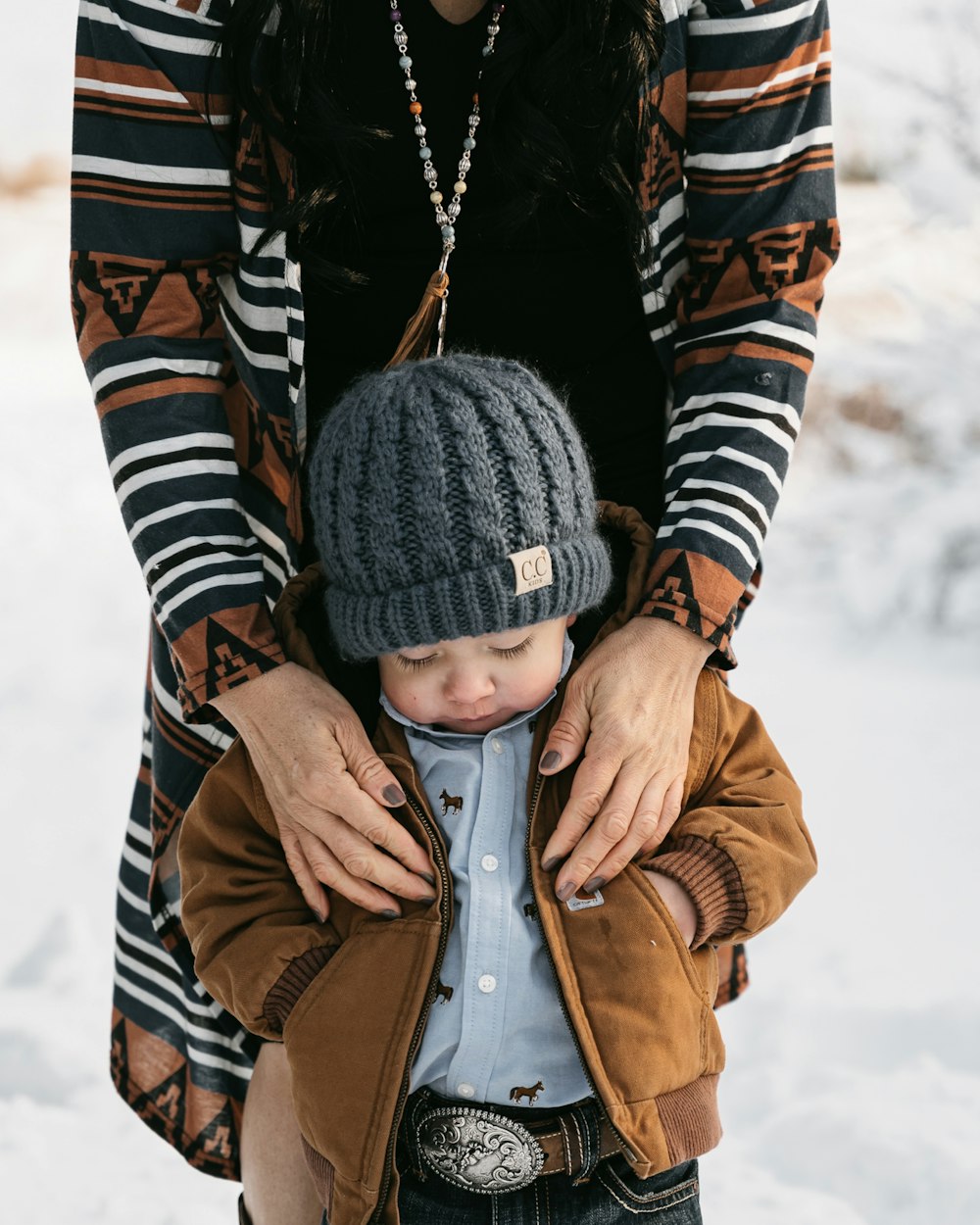 Una mujer sosteniendo a un niño pequeño en la nieve