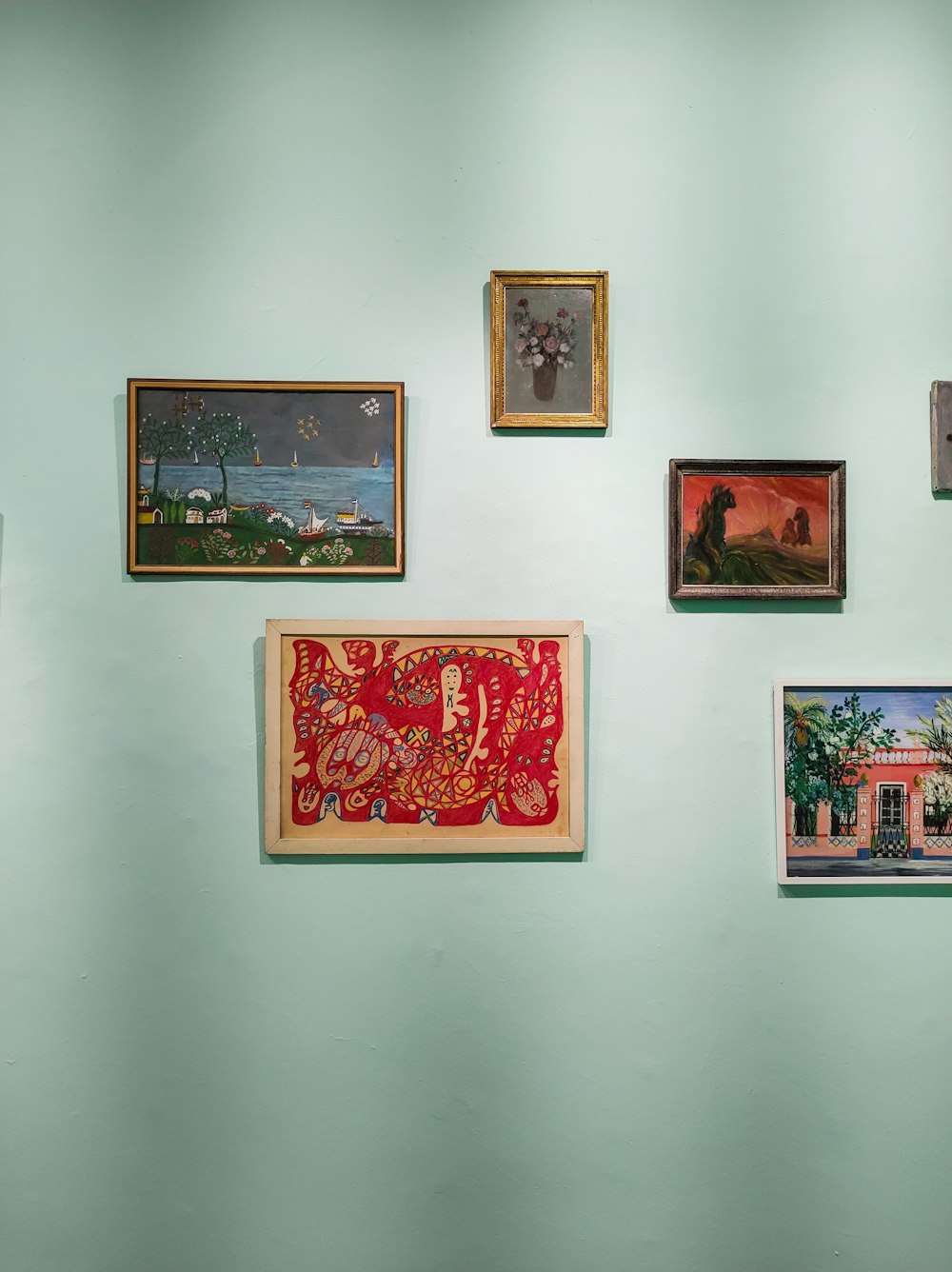 a wall with a bunch of paintings on it