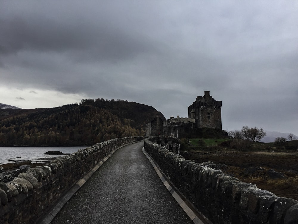 a stone bridge with a castle in the background