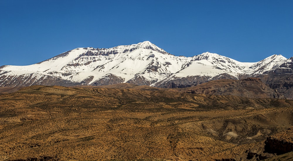 a snow covered mountain range with a clear blue sky