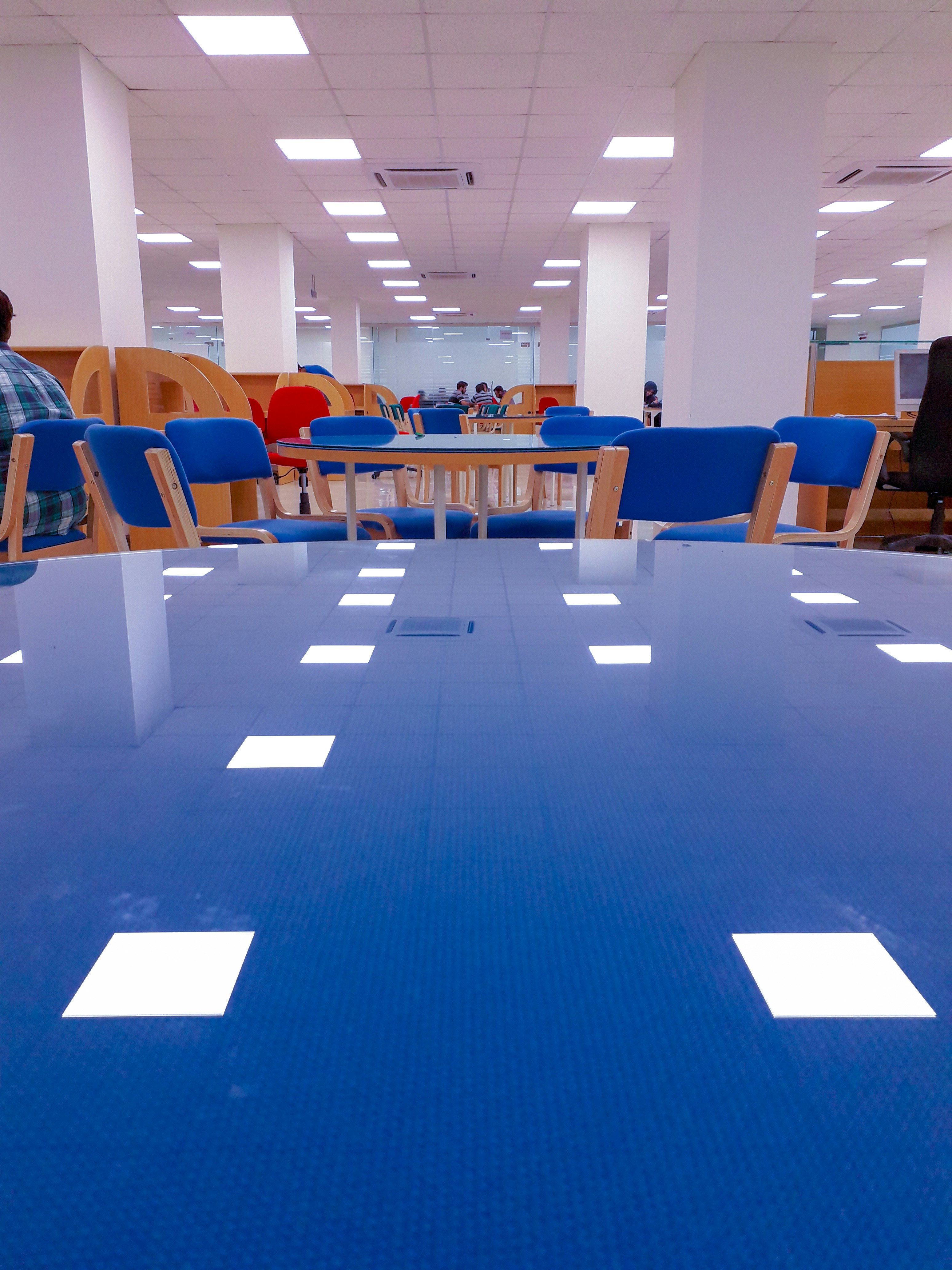 a blue table in a large room with blue chairs