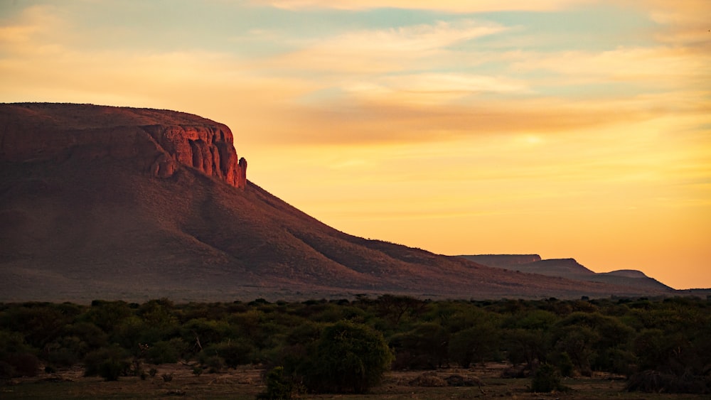 the sun is setting over the mountains in the desert