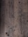 A close-up view of an old, worn-out wooden floor with numerous dark spots and blemishes. The planks show signs of aging and wear, including scratches, dents, and some areas where they appear to be splintering.