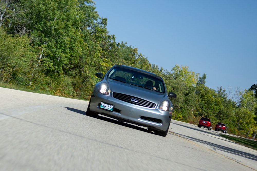 a silver car driving down a curvy road