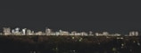 City skyline at sunset with illuminated buildings.