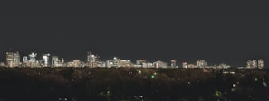 Modern skyline of Dubai at night with illuminated buildings.