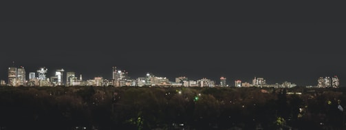 City skyline at sunset with illuminated buildings.