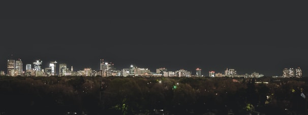 A city skyline at night with illuminated buildings.