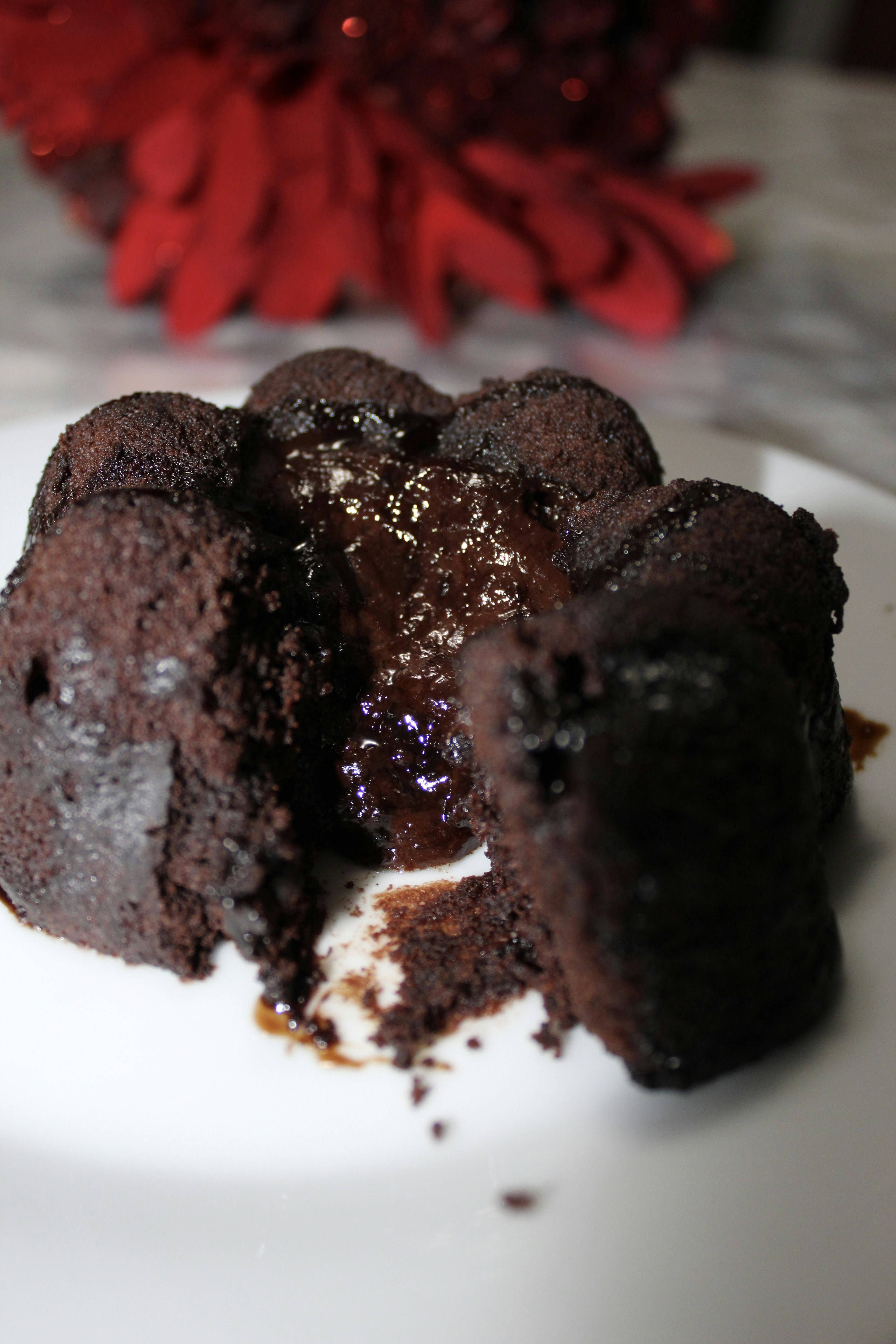Decadent molten chocolate lava cake with liquid chocolate flowing out, vanilla ice cream scoop, dark moody photography