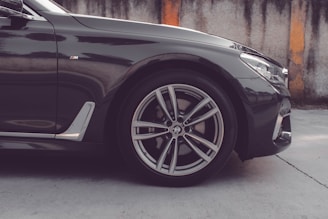 a black car parked in front of a wall