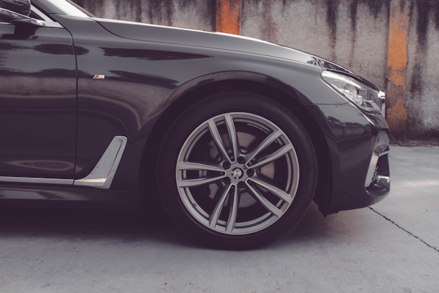 a black car parked in front of a wall