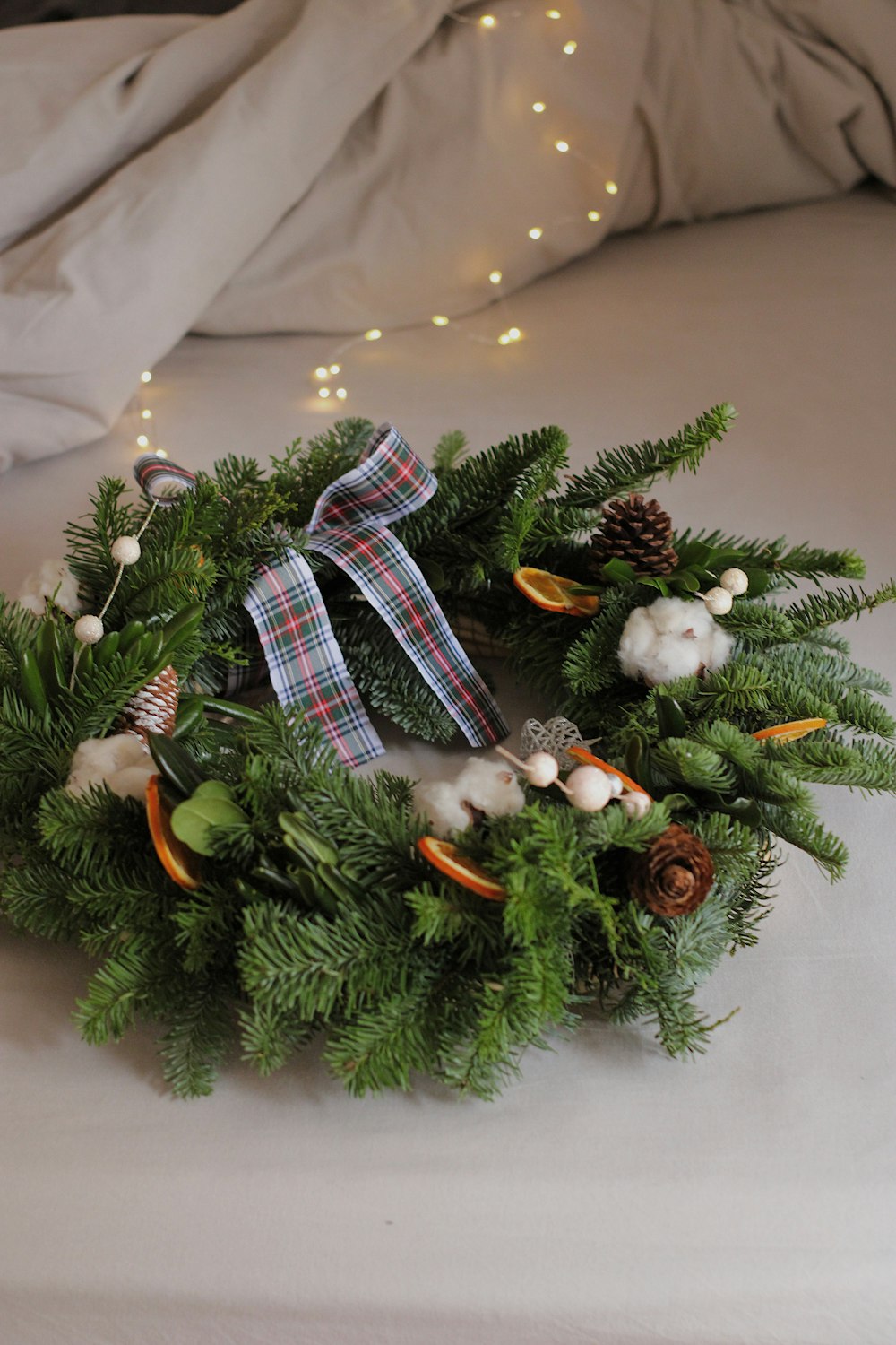 a wreath on a bed with lights in the background