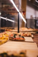 An overhead shot of a variety of healthy pizza slices on a table.