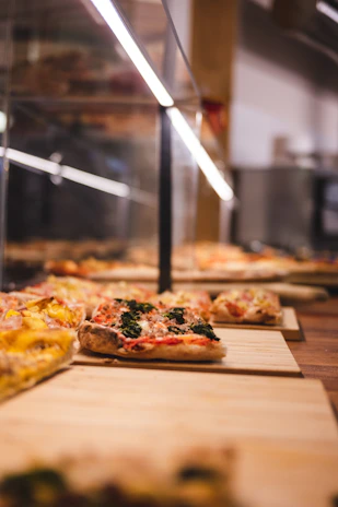 A rustic wooden board displaying several pizza slices with different toppings, inviting to taste