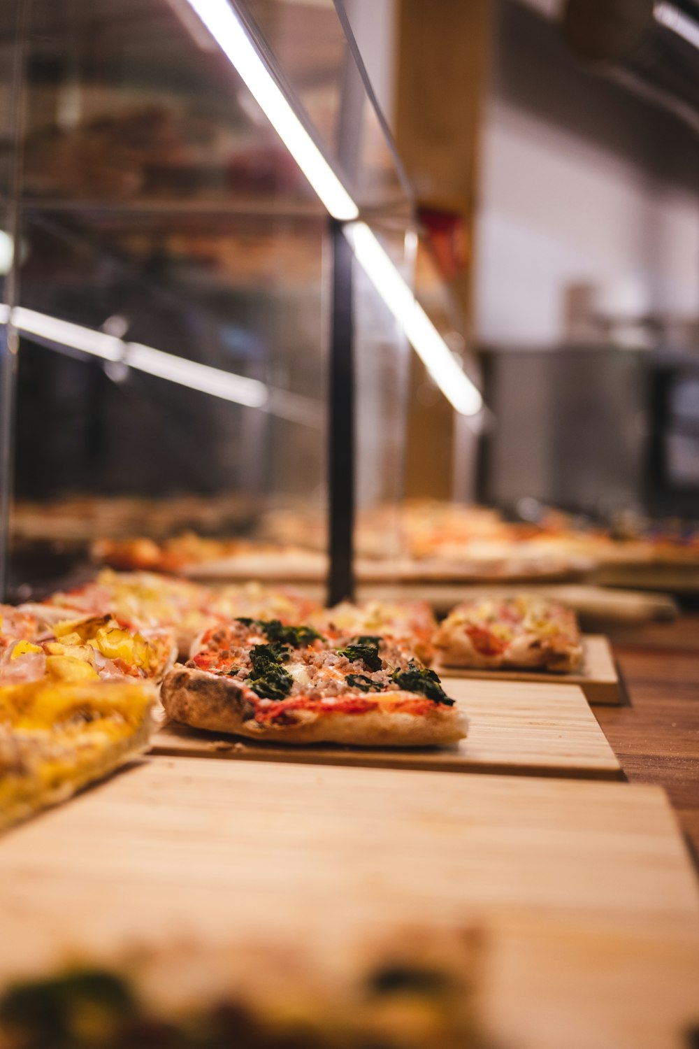 a row of pizzas sitting on top of wooden boards