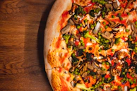 A colorful display of veggie pizza topped with mushrooms, spinach, and olives.