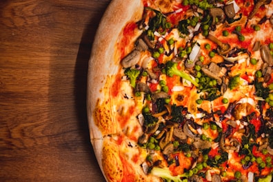 A colorful veggie pizza loaded with fresh peppers, olives, and mushrooms.