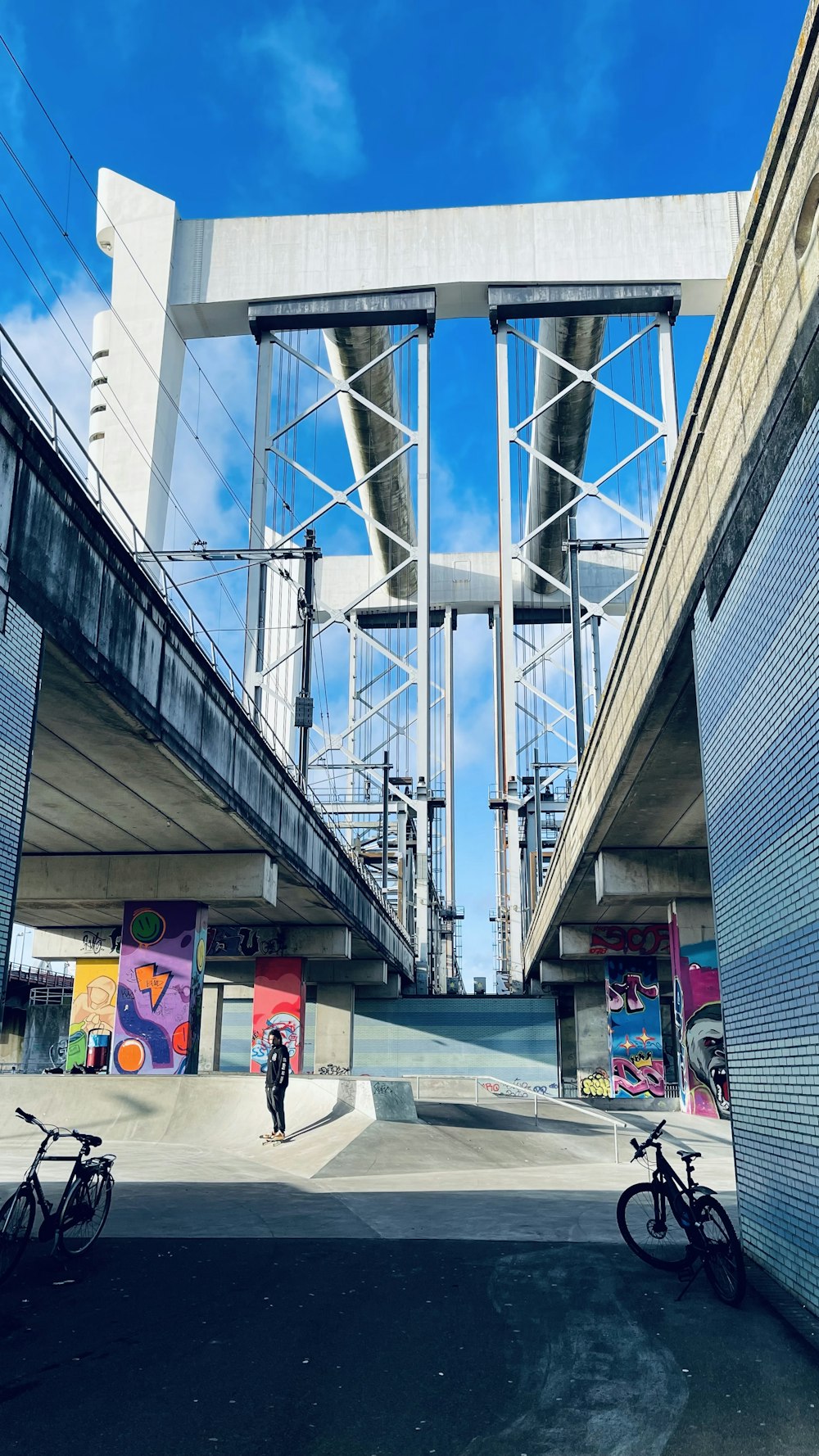 a person standing next to a bike under a bridge