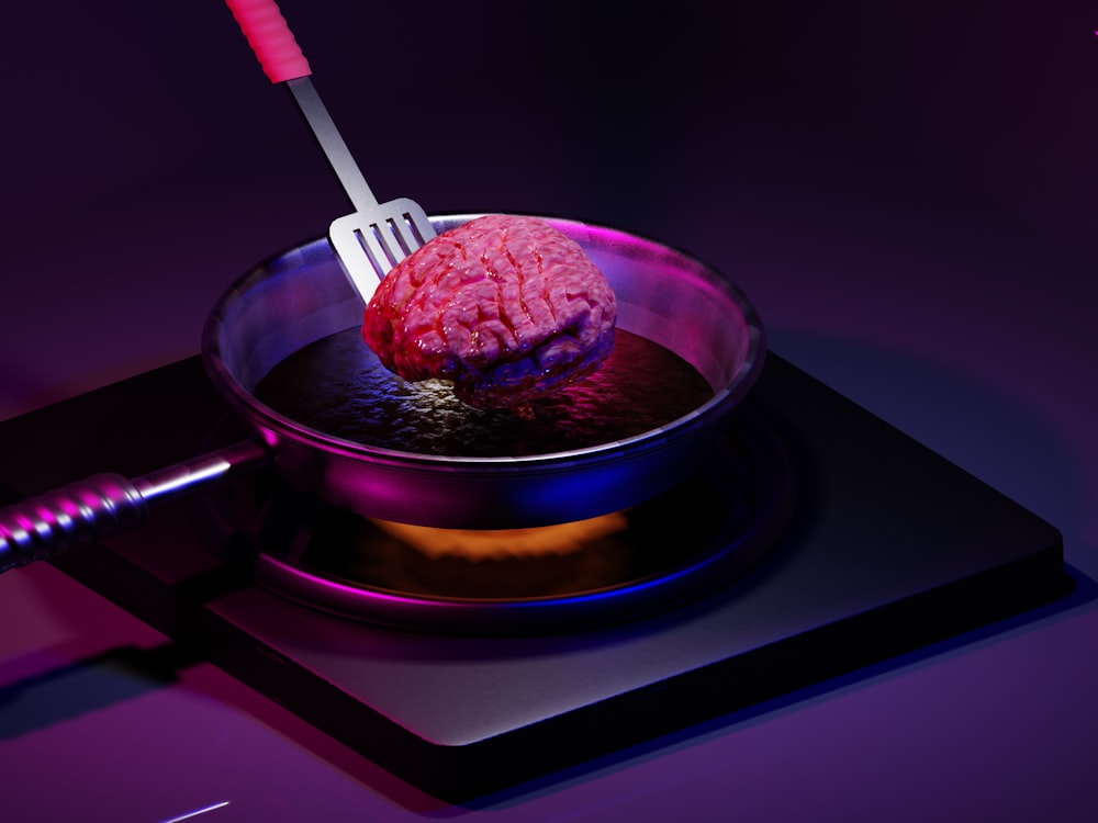 Un cerebro rosado en un tazón con un tenedor en él