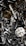 A chaotic assortment of various metal engine parts, including pistons, connecting rods, nuts, bolts, and springs. The components have a metallic sheen, and some show signs of wear and oxidation, suggesting they are used or discarded.