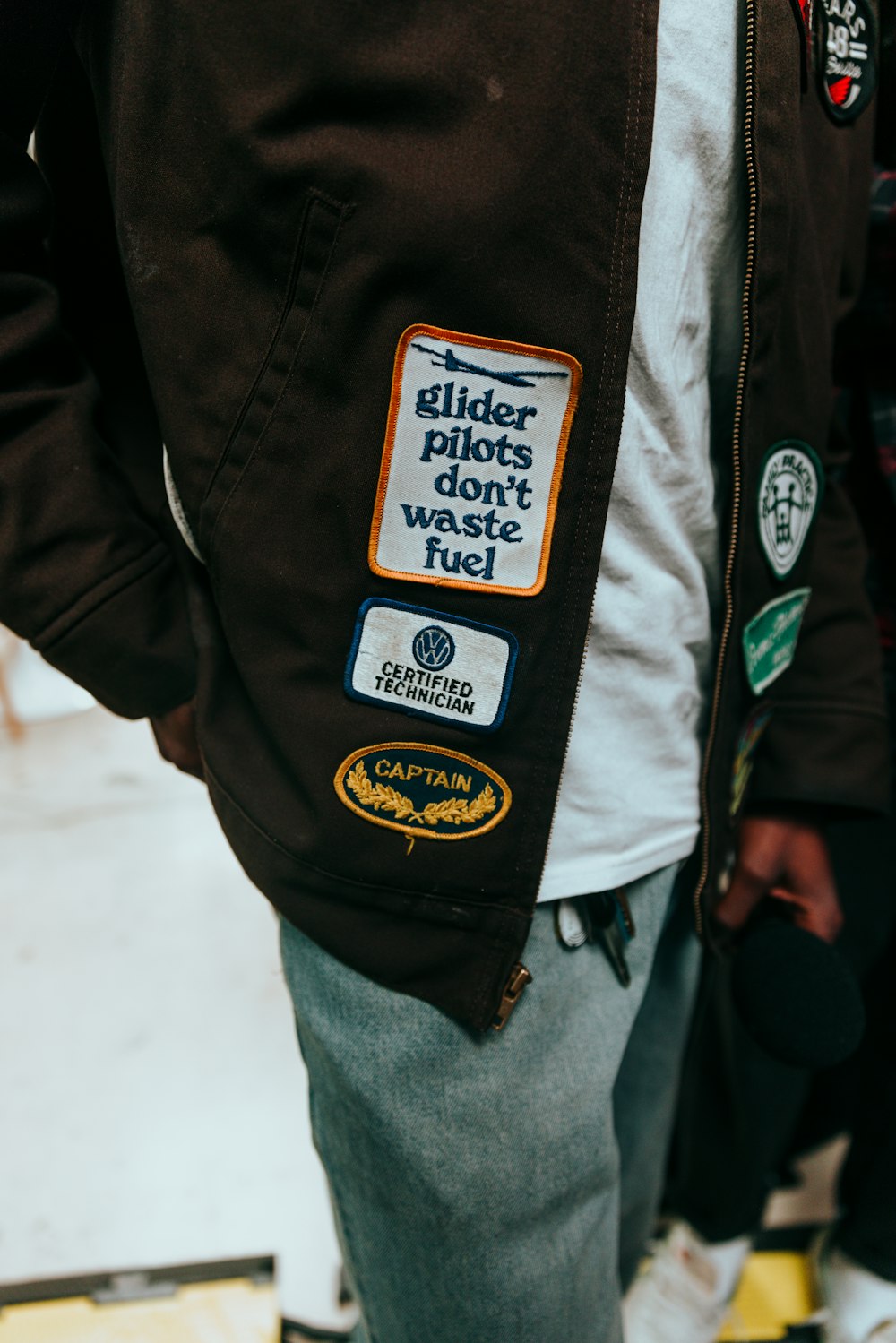 a close up of a person wearing a jacket with stickers on it