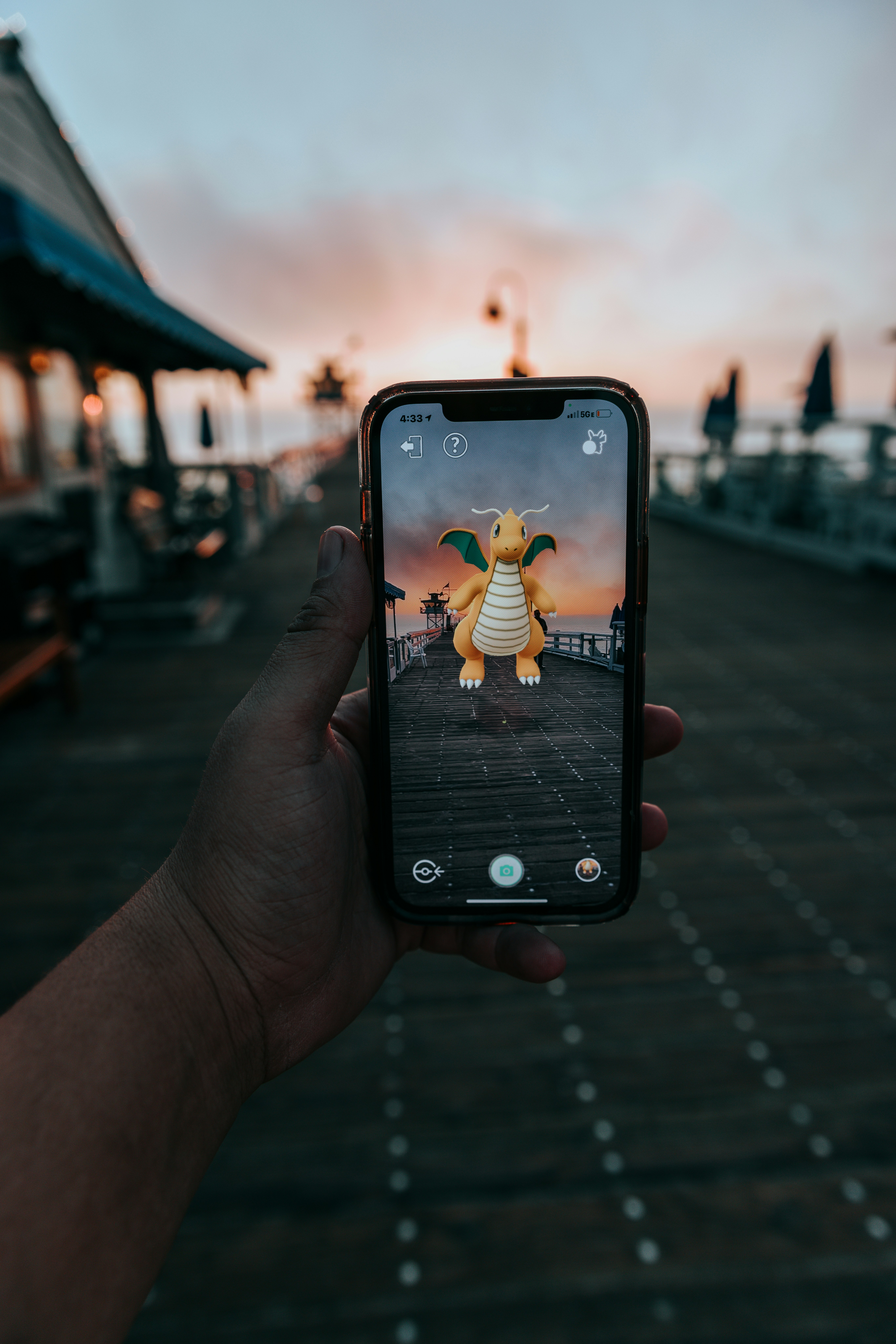 a person holding up a cell phone with a picture of a dragon on it