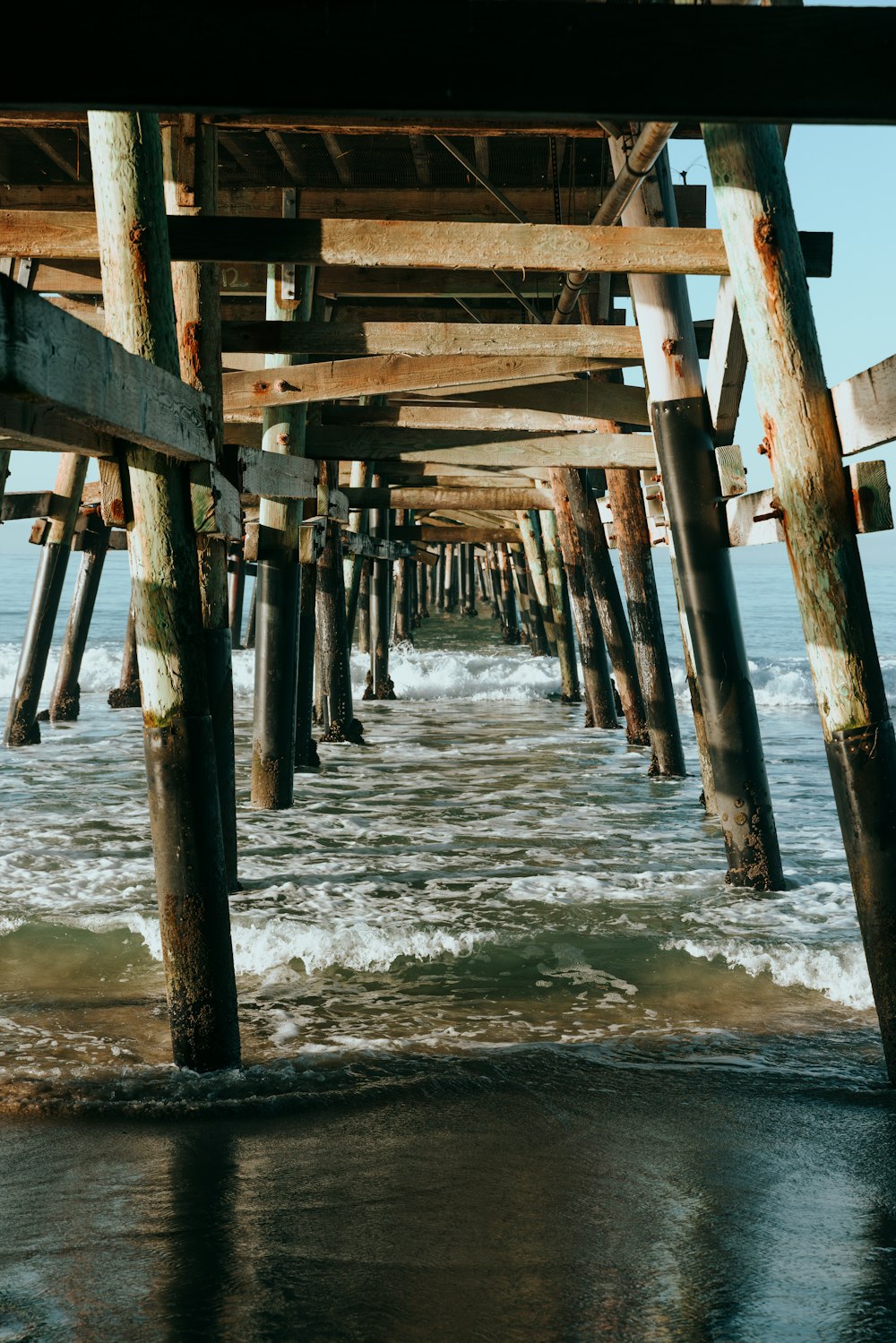 a view of the ocean under a pier