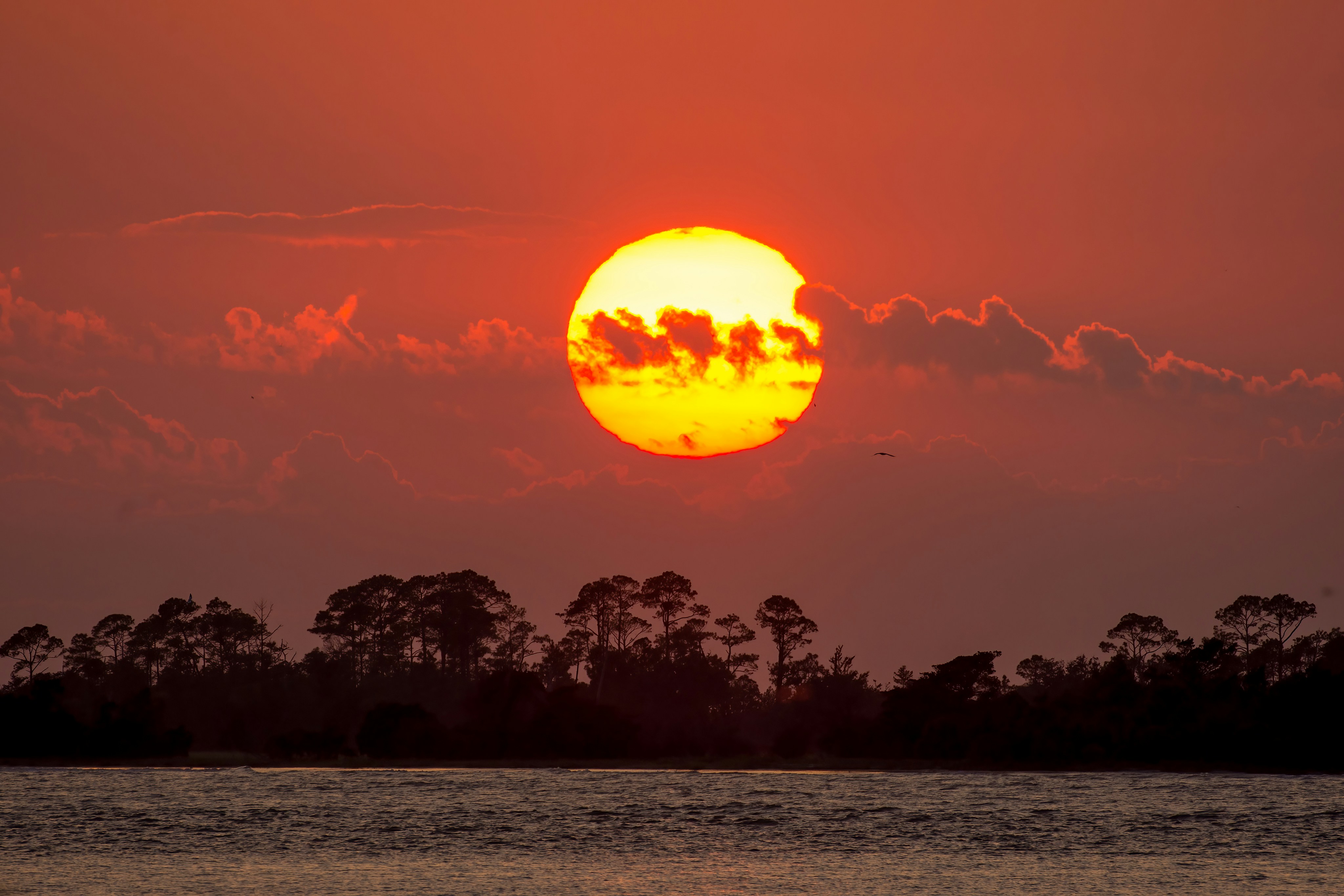 the sun is setting over a body of water