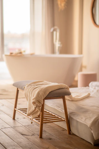 A serene spa room bathed in soft natural light with plush towels and aromatic candles.