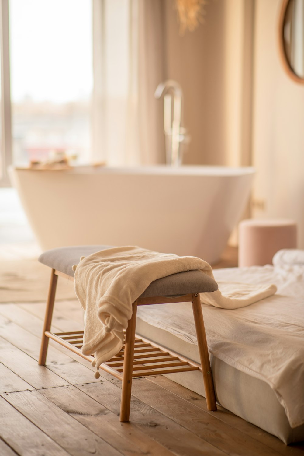 a white bath tub sitting next to a wooden floor