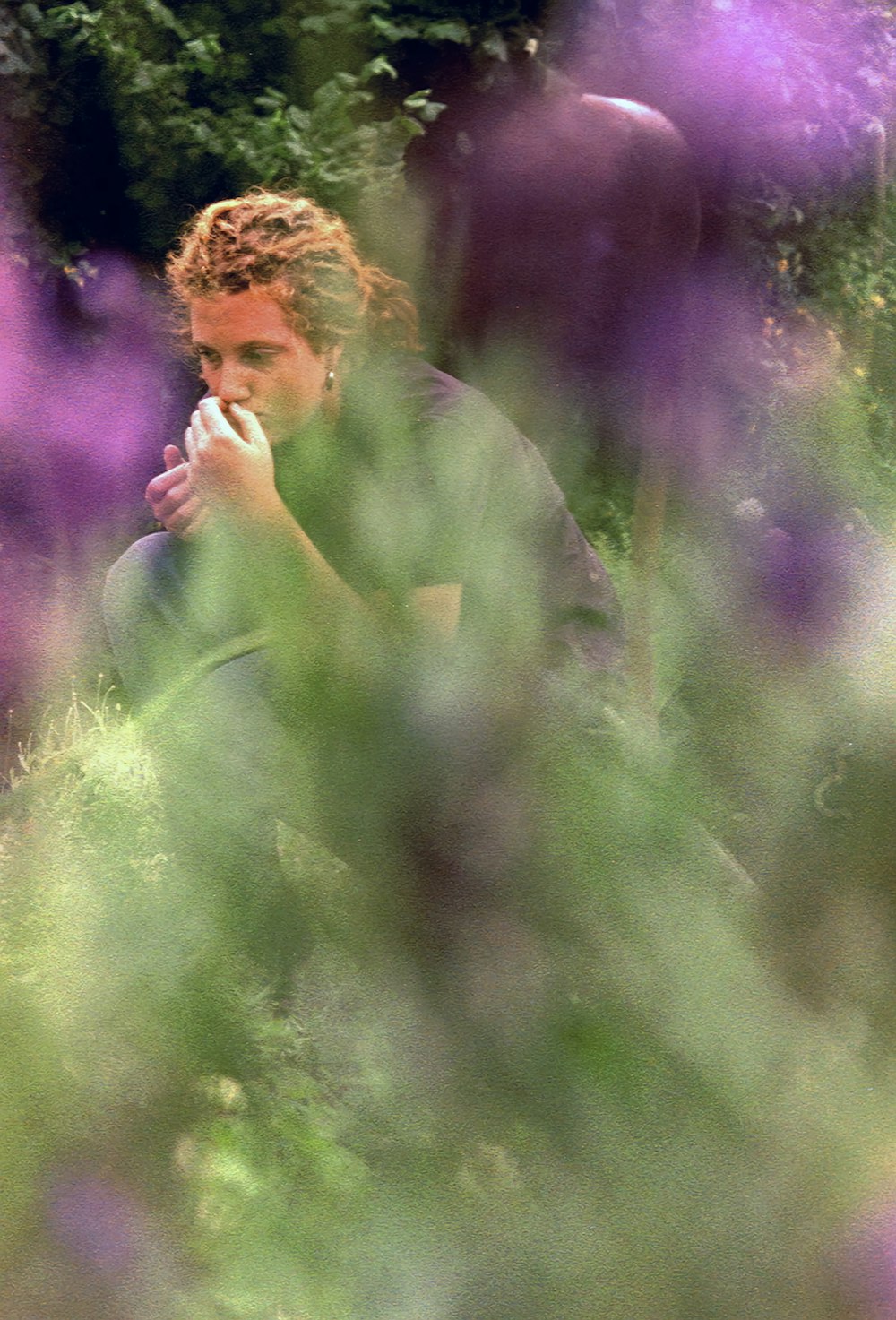 a man sitting in a field of purple flowers