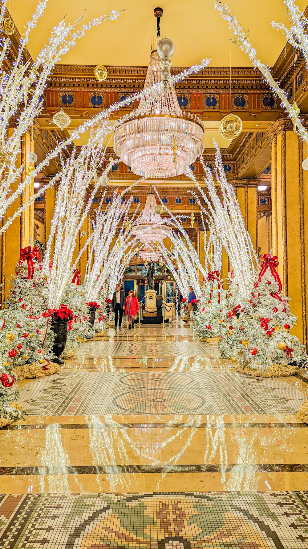 a large room with a chandelier and christmas decorations