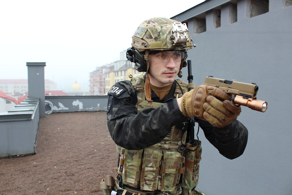 a man in camouflage holding a machine gun