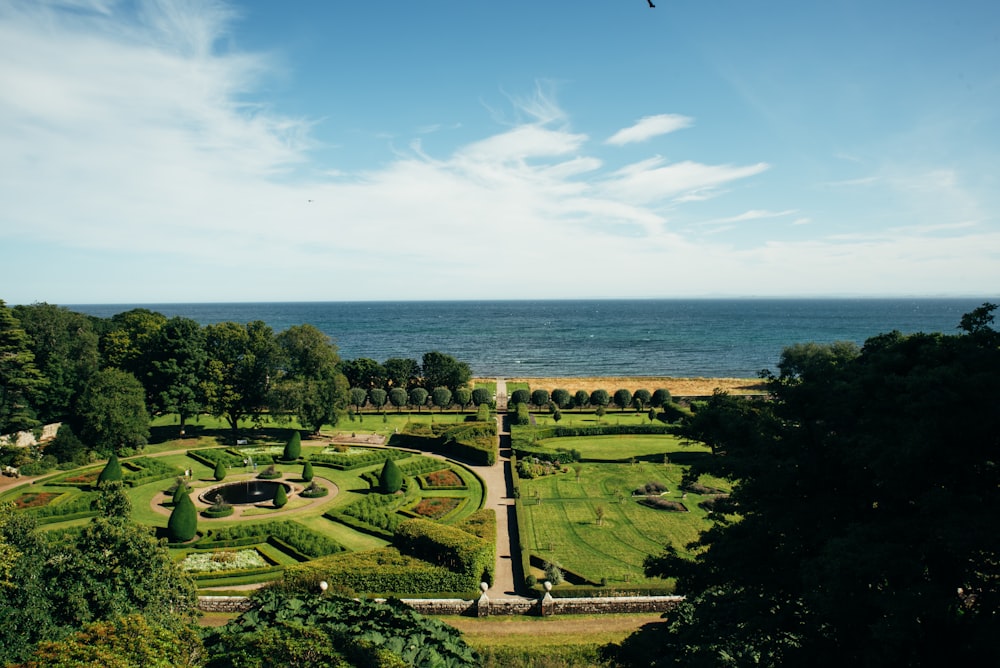 an aerial view of a garden with a view of the ocean