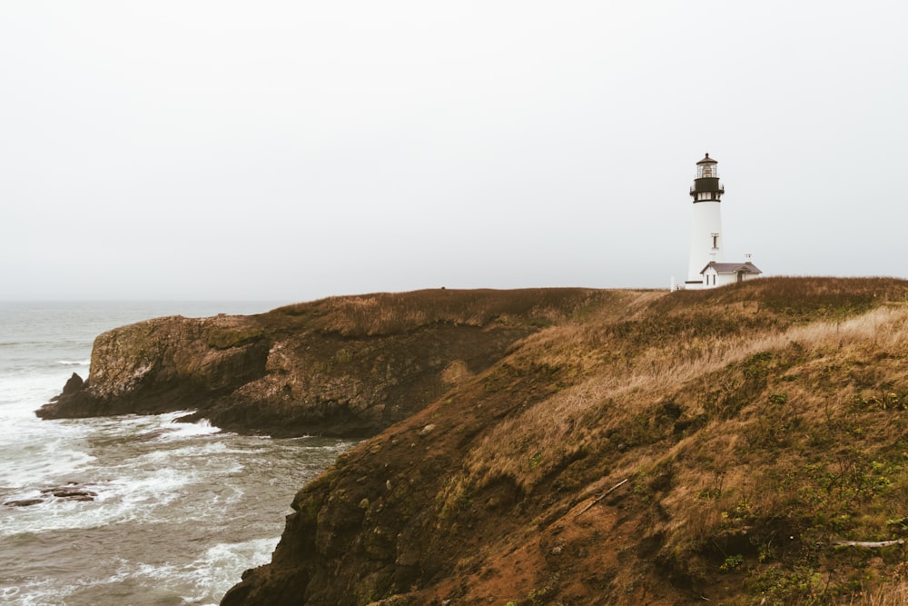 a light house sitting on top of a cliff next to the ocean