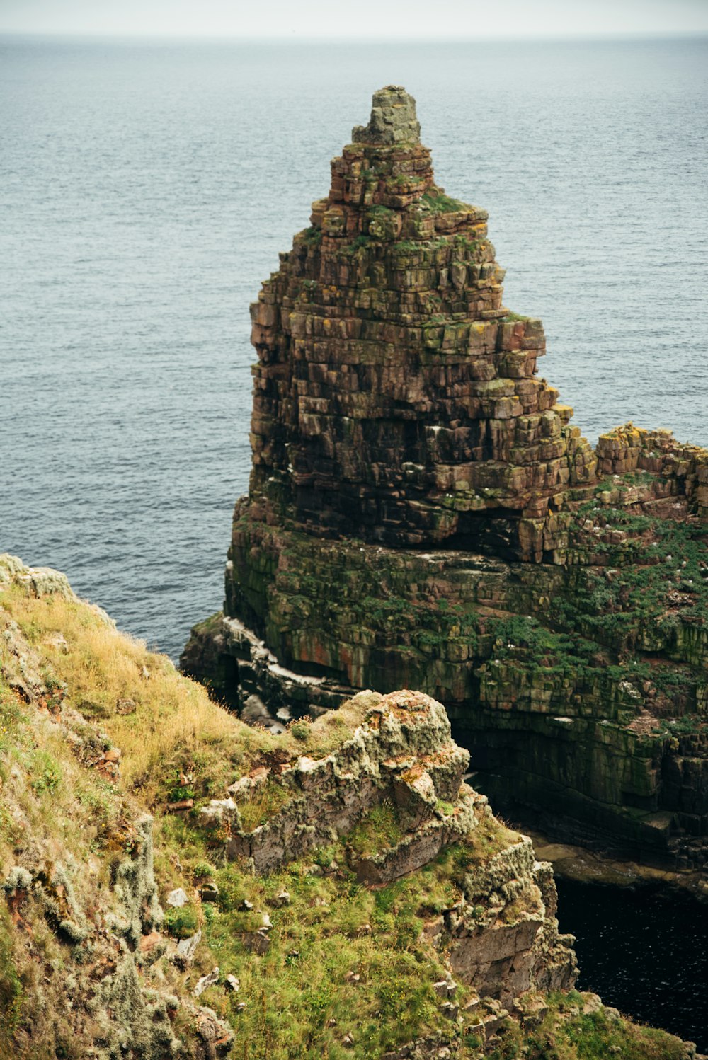 a large rock formation sitting on the side of a cliff