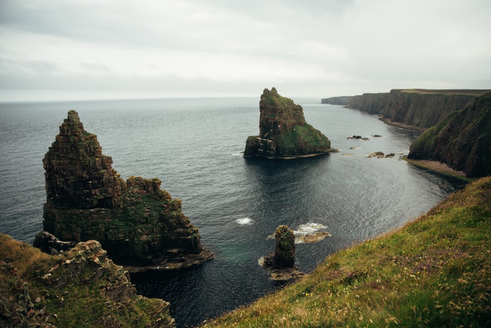 a large body of water surrounded by a lush green hillside