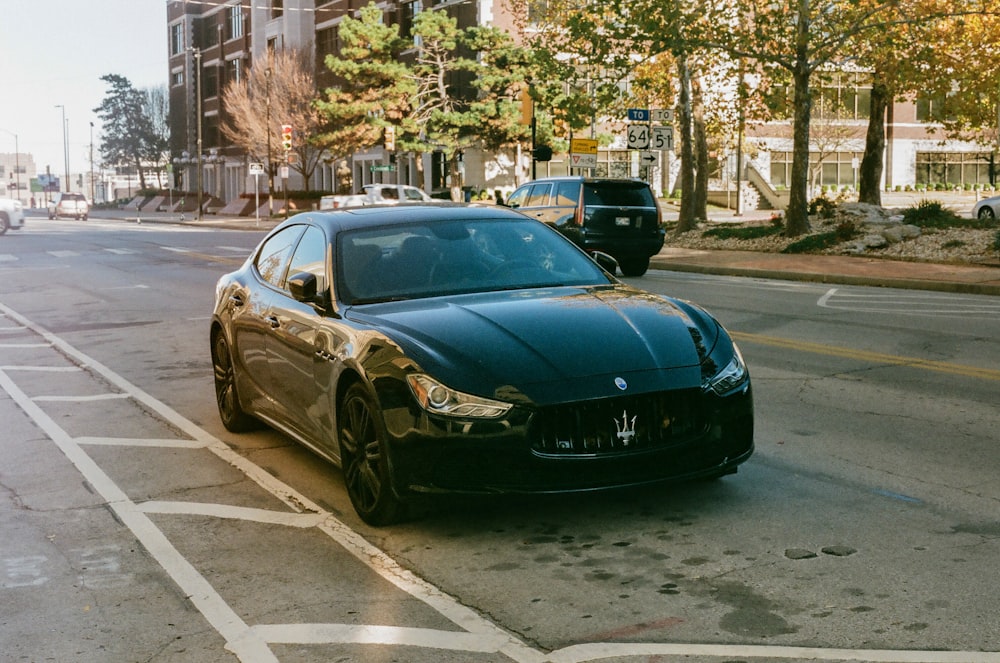 a black masera parked on the side of the road