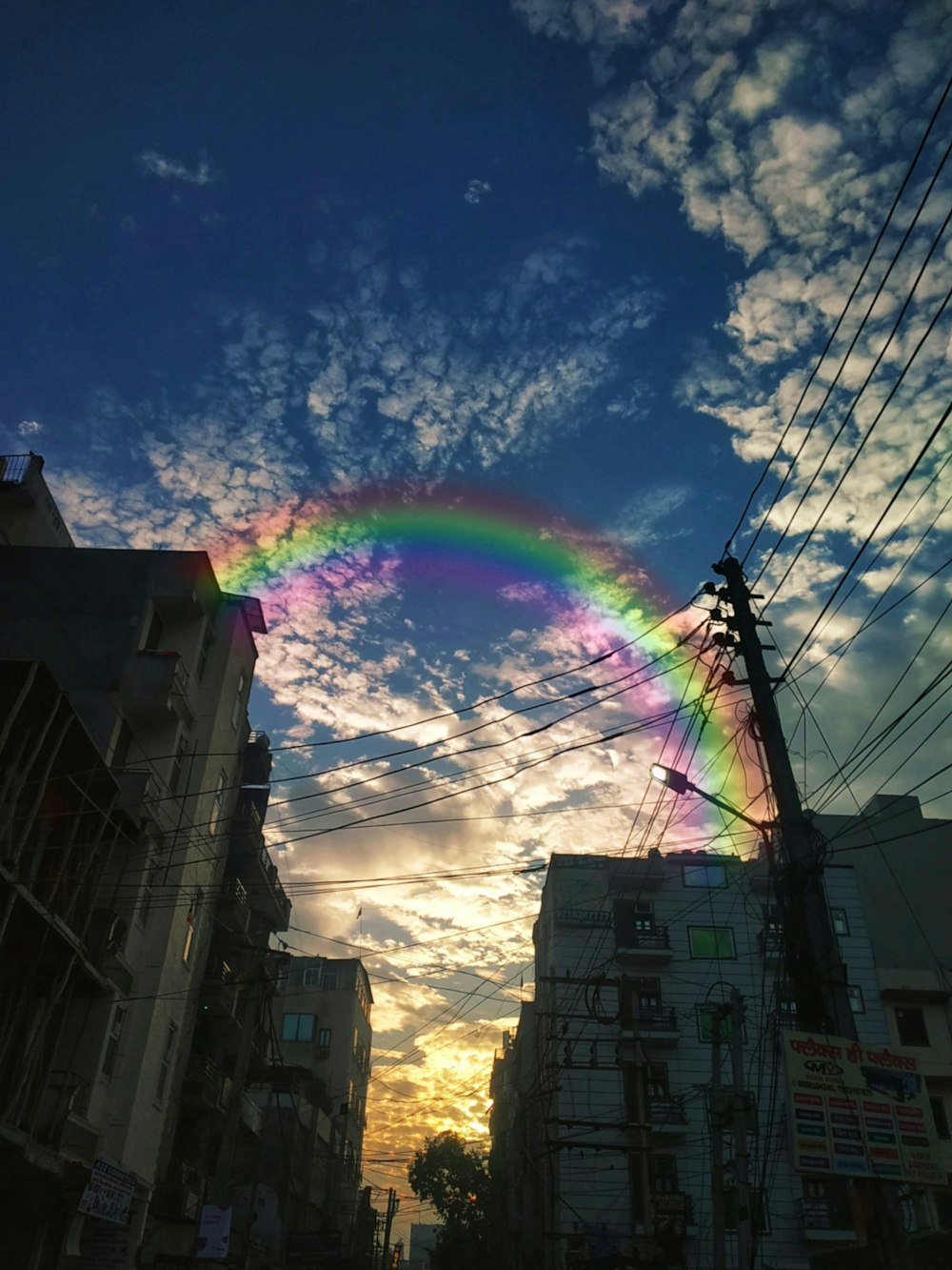 a rainbow in the sky over a city street