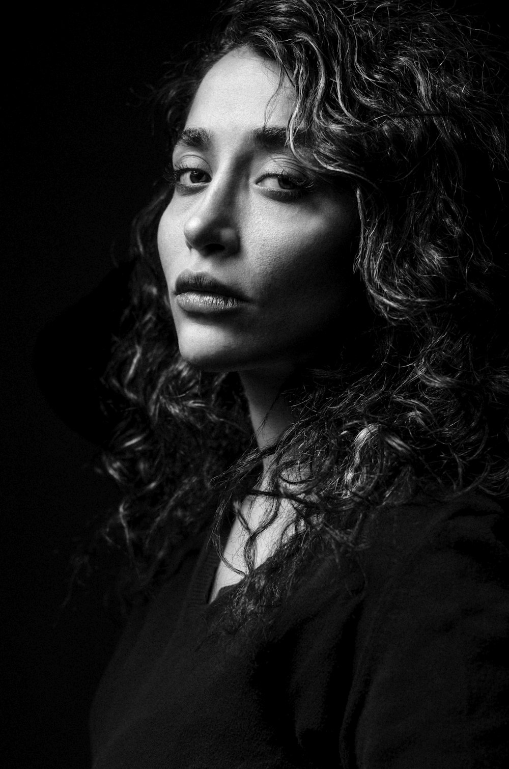 a black and white photo of a woman with curly hair