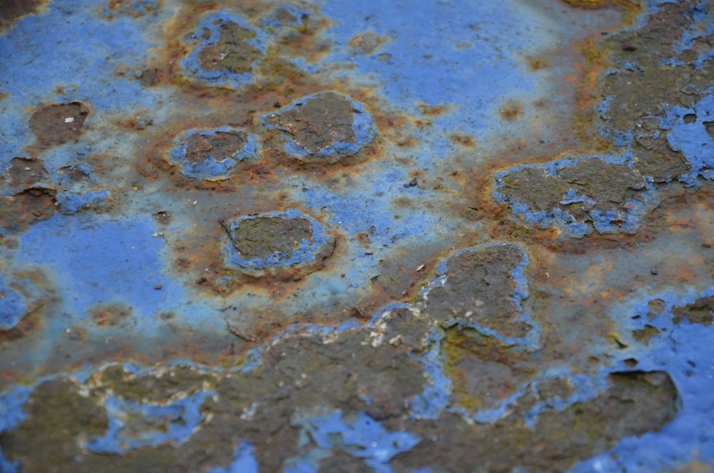 a rusted metal surface with blue paint