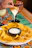 Close-up of a golden, crispy tequeño being dipped into a creamy sauce.
