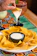 Close-up of a golden, crispy tequeño being dipped into a creamy sauce.
