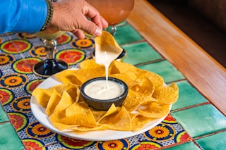 a plate of nachos and a drink on a table